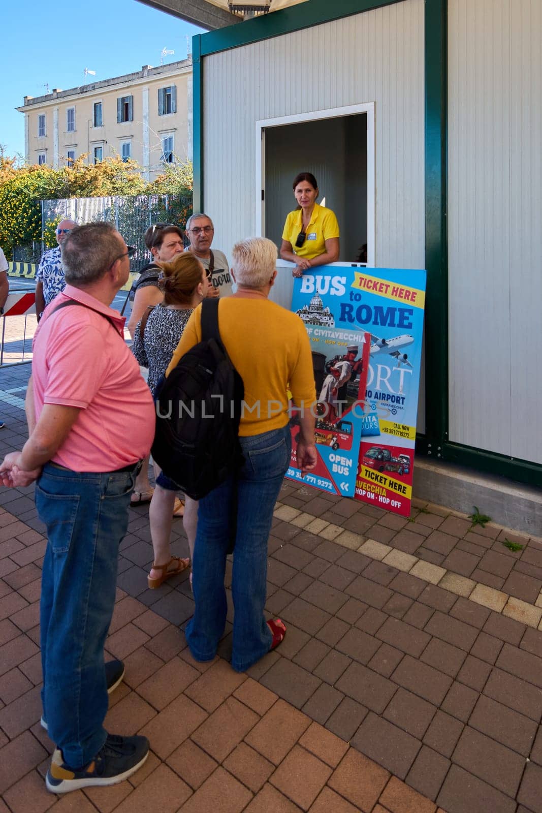 Civitavecchia. Italia - December 19, 2024: Travelers lining up for tickets at a booth offering bus rides to Rome from the port of Civitavecchia. Concept: Travel logistics and public transportation.