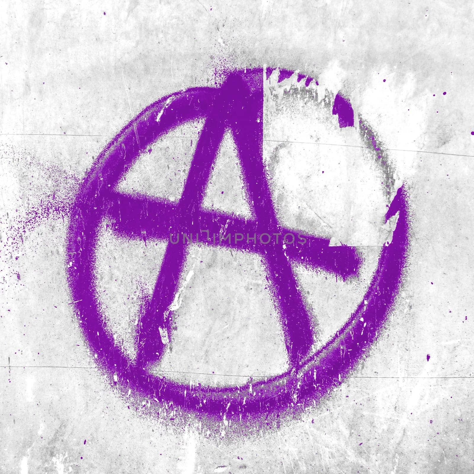 Purple symbol of anarchy painted on the peeling old wall. Ideal for textures, backgrounds and concepts.