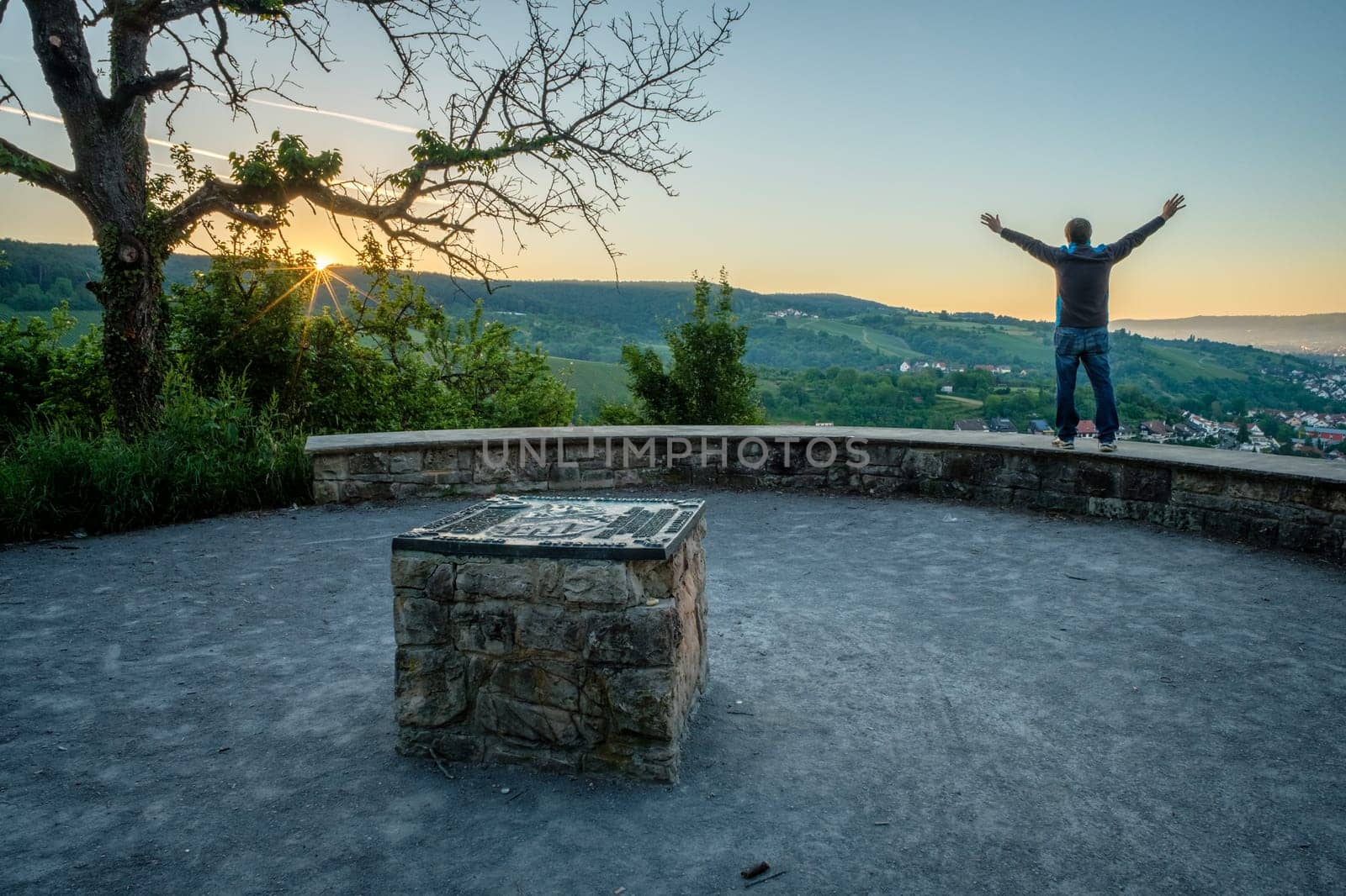Man with arms in the air enjoy the sunrise with rays