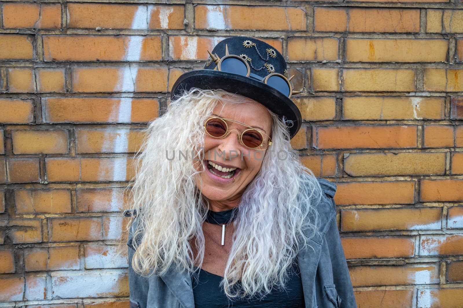 Laughing Steam Punk Lady standing on a Brick Wall Background