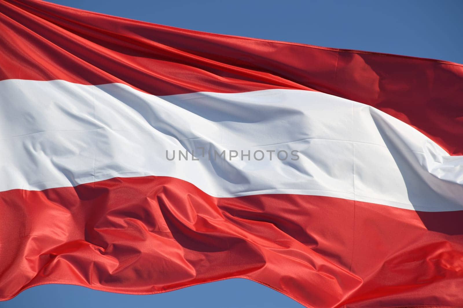 The red,white,red Austrian national flag waves in the wind.