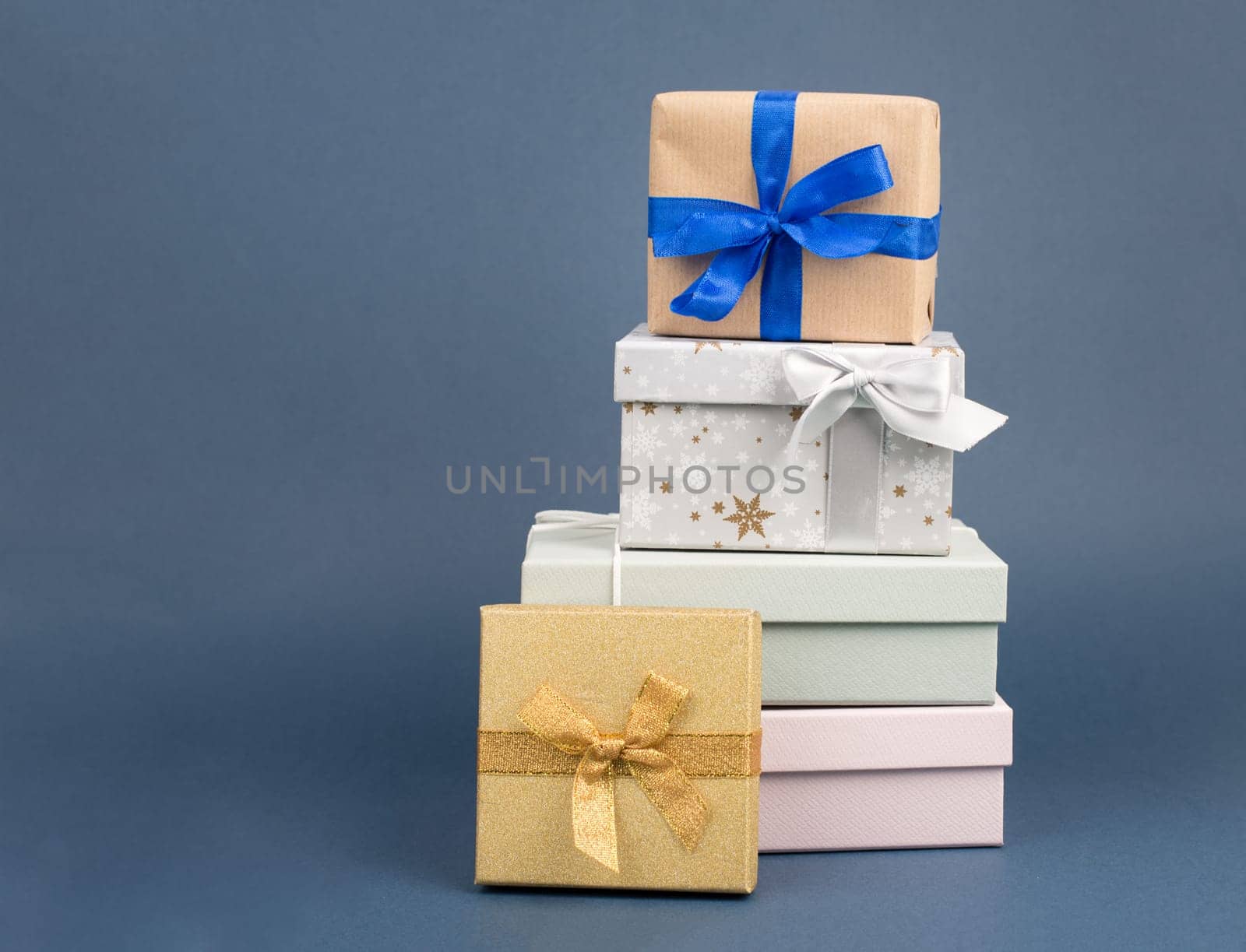 Gift boxes in different sizes and colors in front of a dark blue background, copy space, christmas, birthday, holiday presents