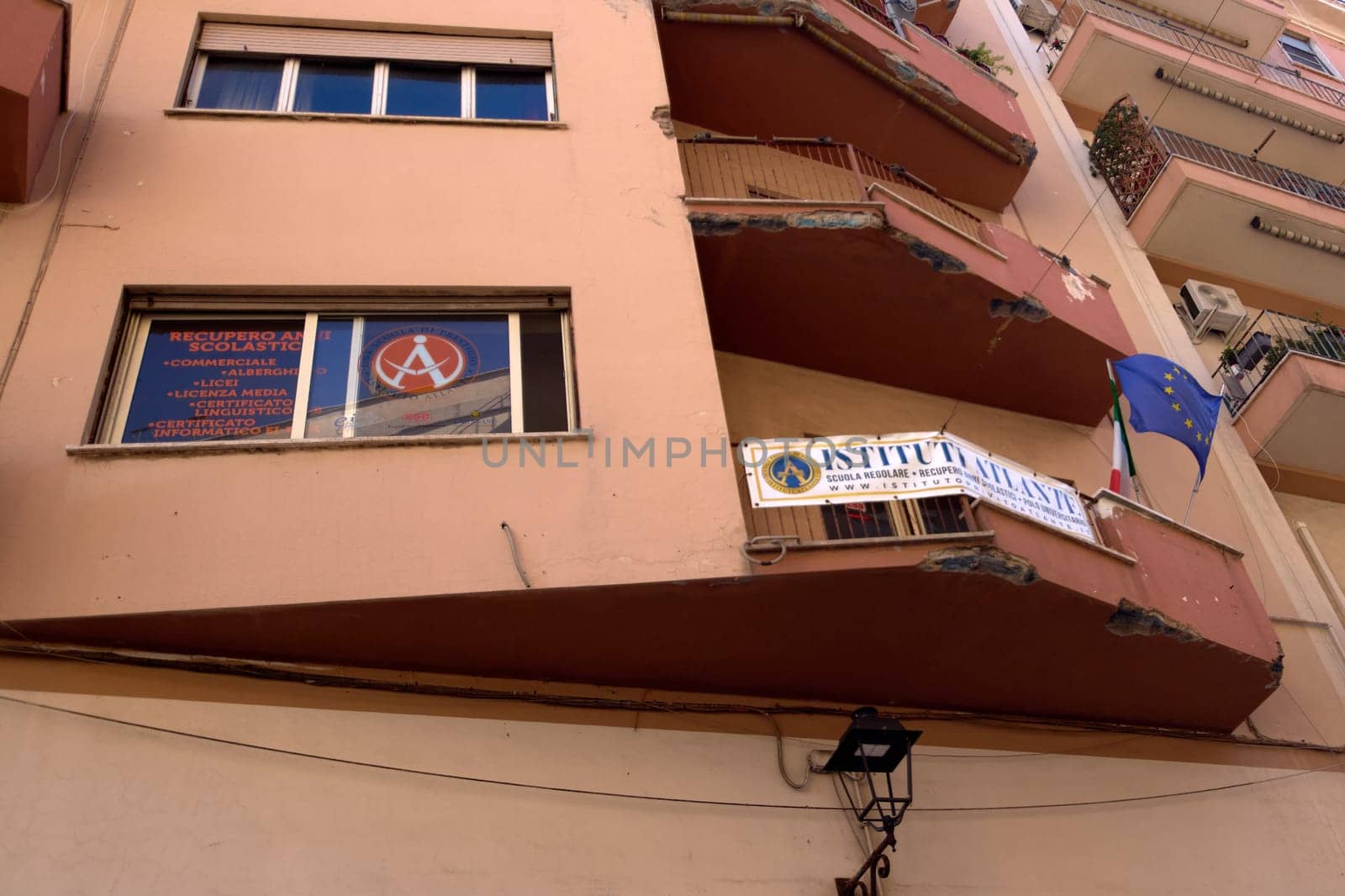 Civitavecchia, Italy - December 19, 2024: Educational institute showing the courses offered. Above, a balcony with a banner and flags of Italy and the European Union. Concept: Education and training.