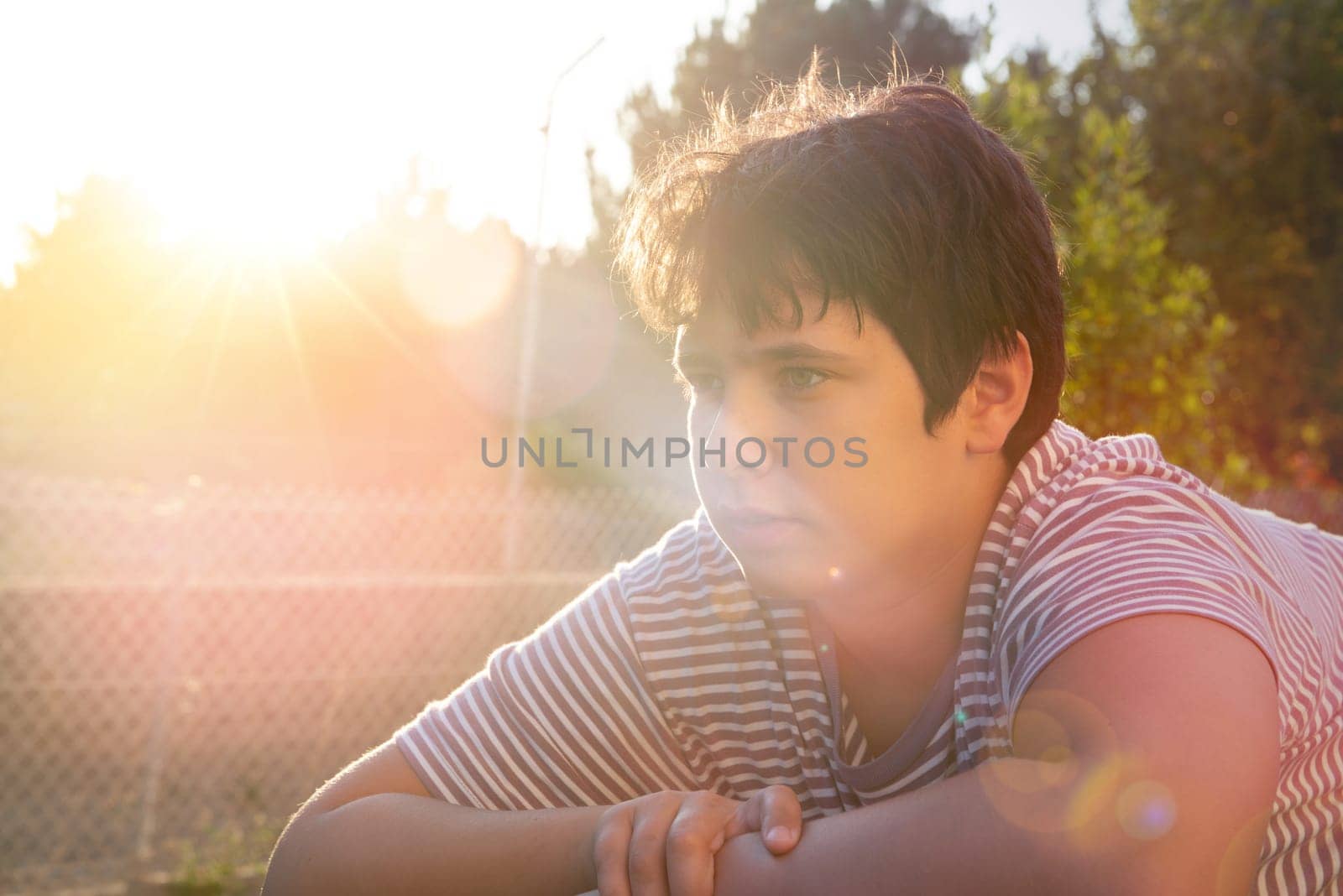 Happy handsome boy posing outdoors at sunset