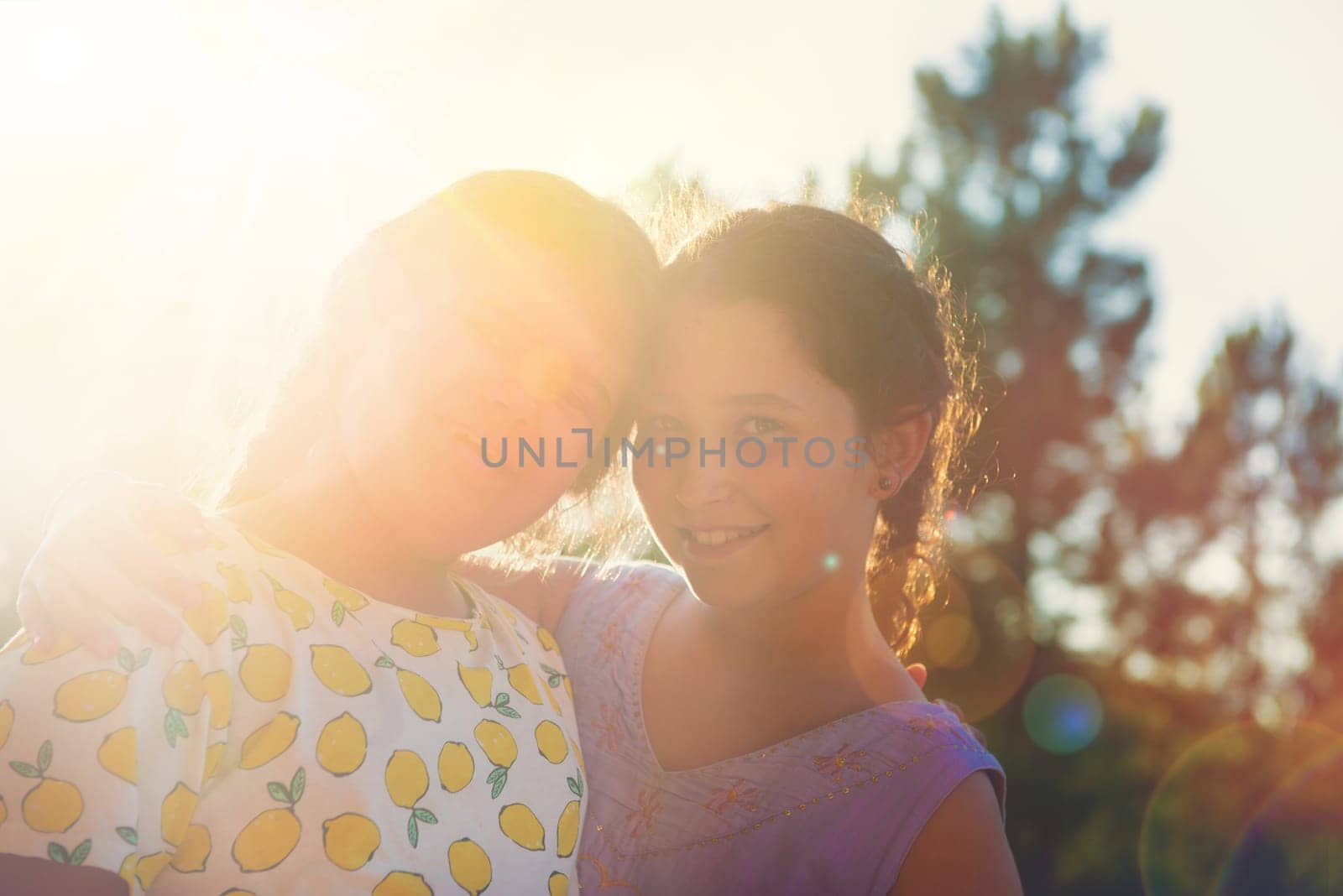 Sweet young girls posing outdoors at sunset