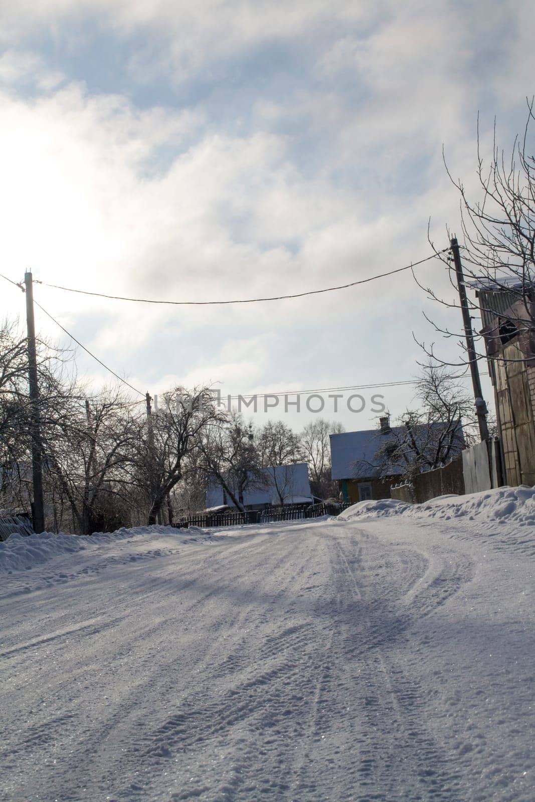 Road in the snow in the rural village in Belarus. Vertical image
