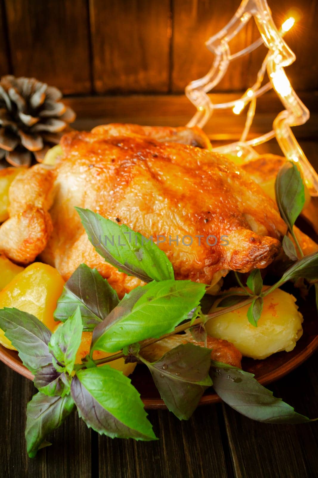 Baked chicken, the Christmas table is served with a turkey, decorated with lights. Fried chicken, table. Christmas dinner. Vertical image