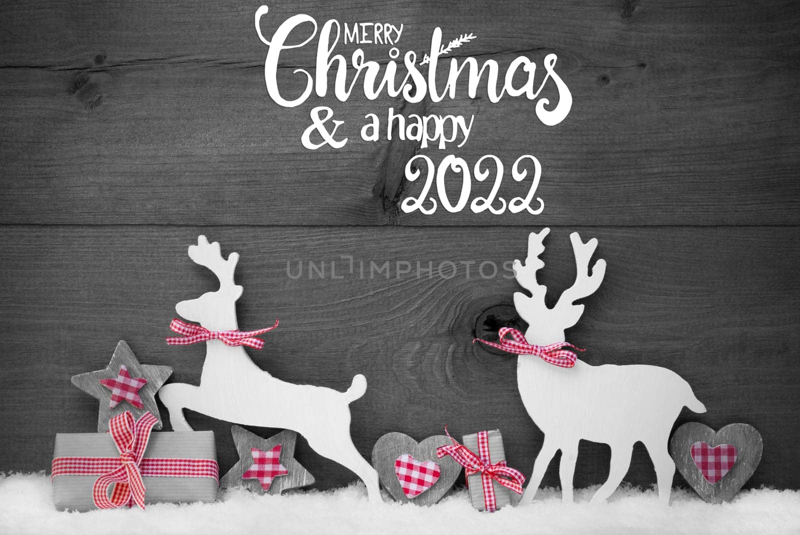 English Calligraphy Merry Christmas And Happy 2022. Wooden Christmas Ornament Like Present, Heart, And Wooden Deer. Gray Wooden Background With Snow