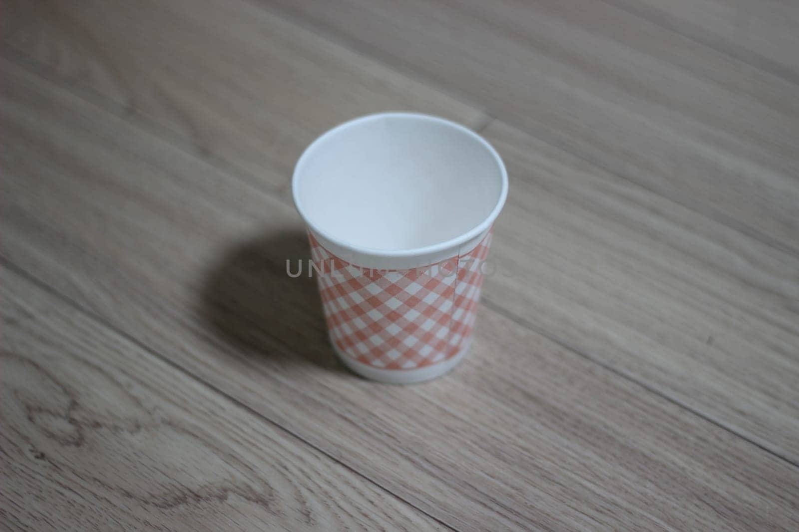 Paper, cardboard disposable glass on a wooden floor. Disposable paper cups on the wooden floor