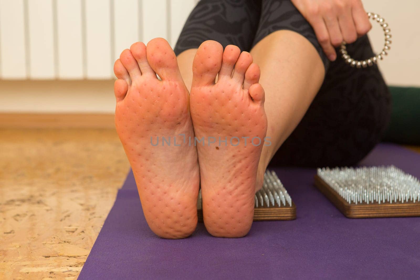 practice of standing on nails. Close-up of a yoga man standing on a sadhu board with sharp nails. Wooden sadhu board with nails for sadhu practice
