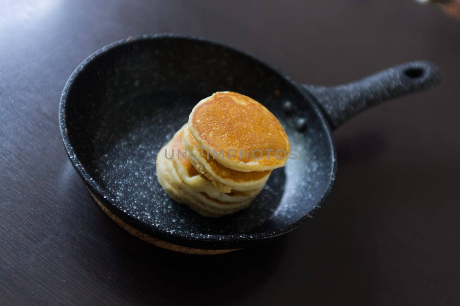 A pancakes in a frying pan on black background