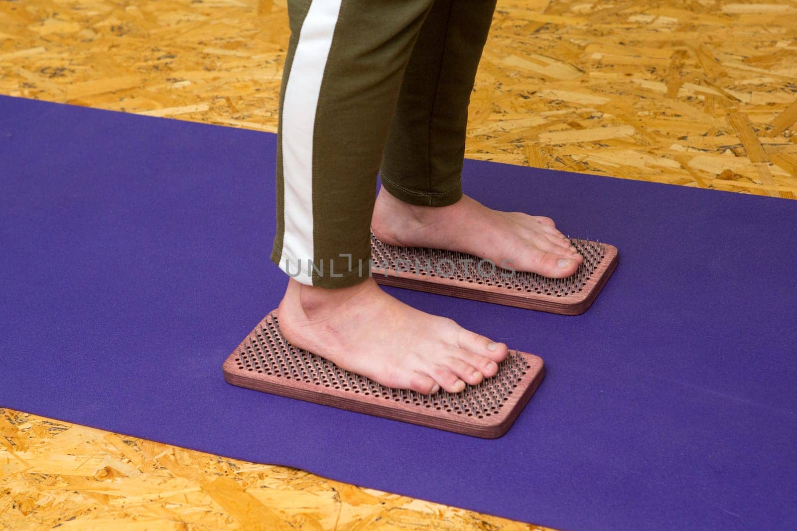 practice of standing on nails. Close-up of a yoga man standing on a sadhu board with sharp nails. Wooden sadhu board with nails for sadhu practice