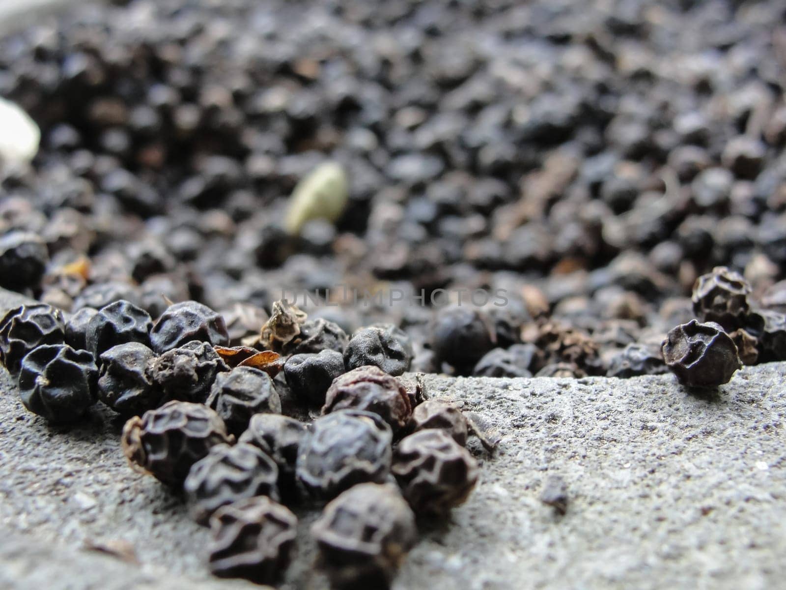 Black pepper peas in stone mortar, selective focus, texture, background