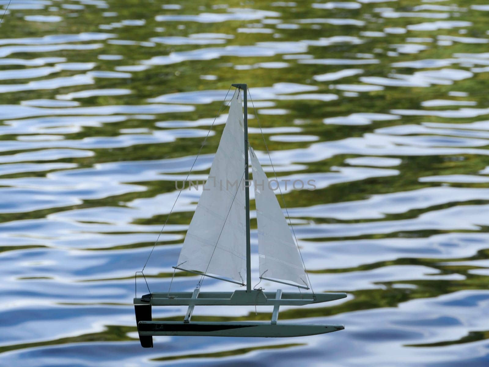 small sailing catamaran on the waves children's toy sailing