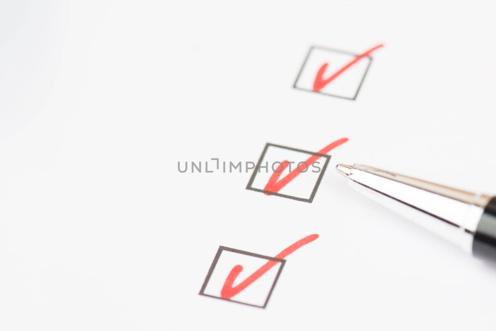 Red colored checkmarks in little black boxes, white paper, education, test, to do list, busniss concept