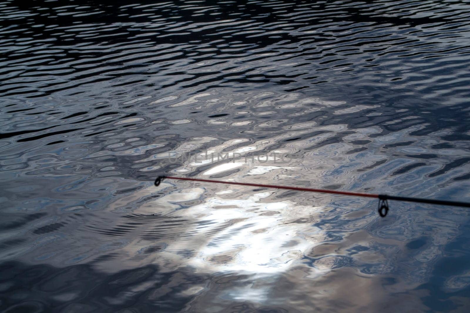 fishing float on the water, fishing rod on water background close up