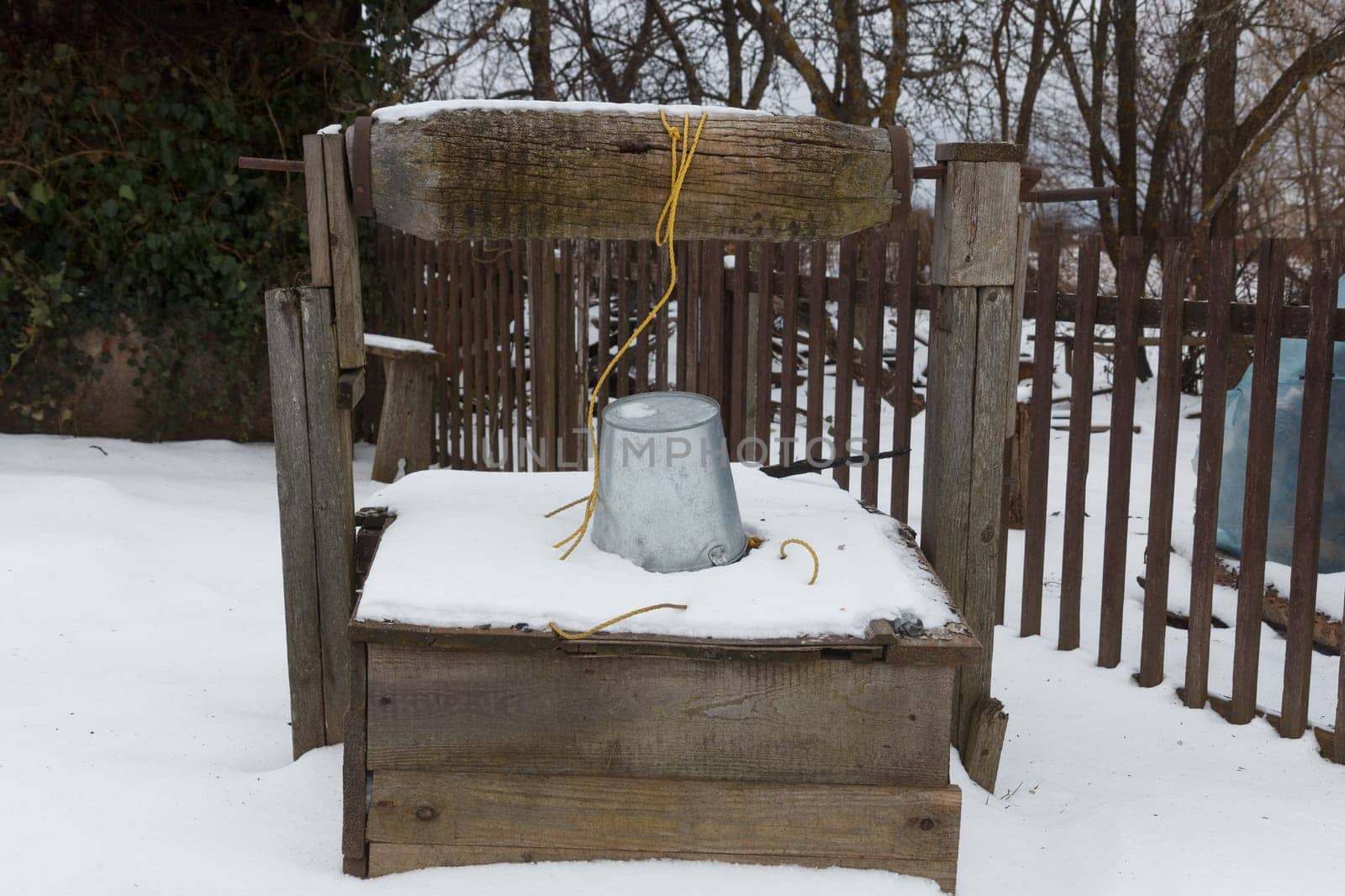 old water well covered with snow in winter