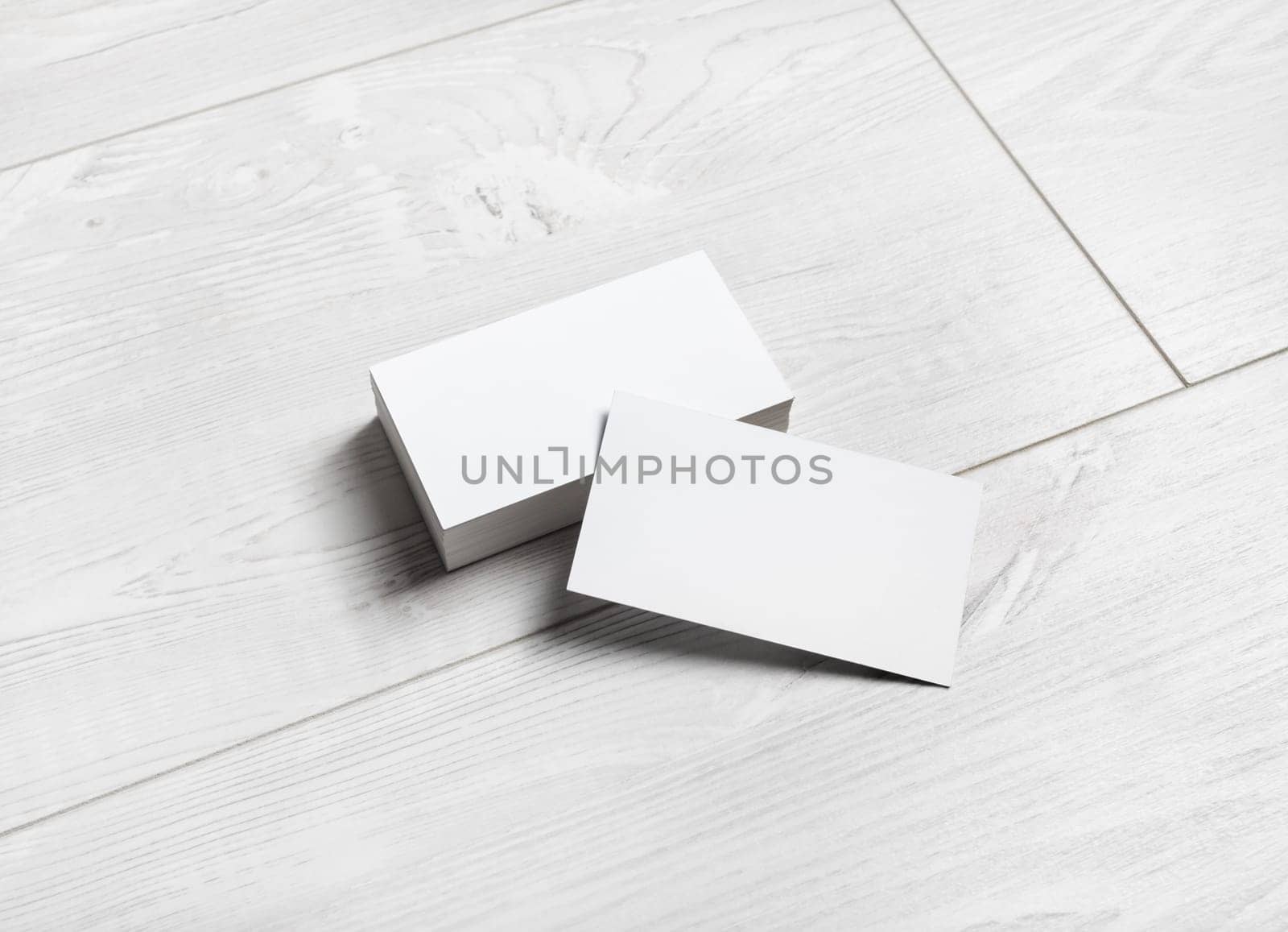Blank white business cards on wooden background.