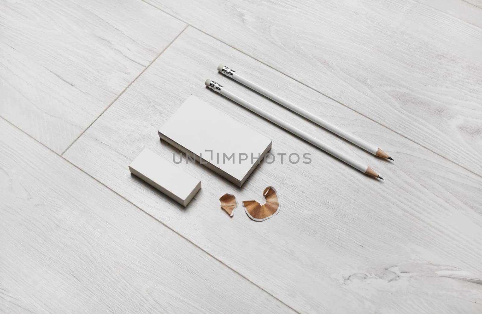Blank business cards, pencils and eraser on wooden background.