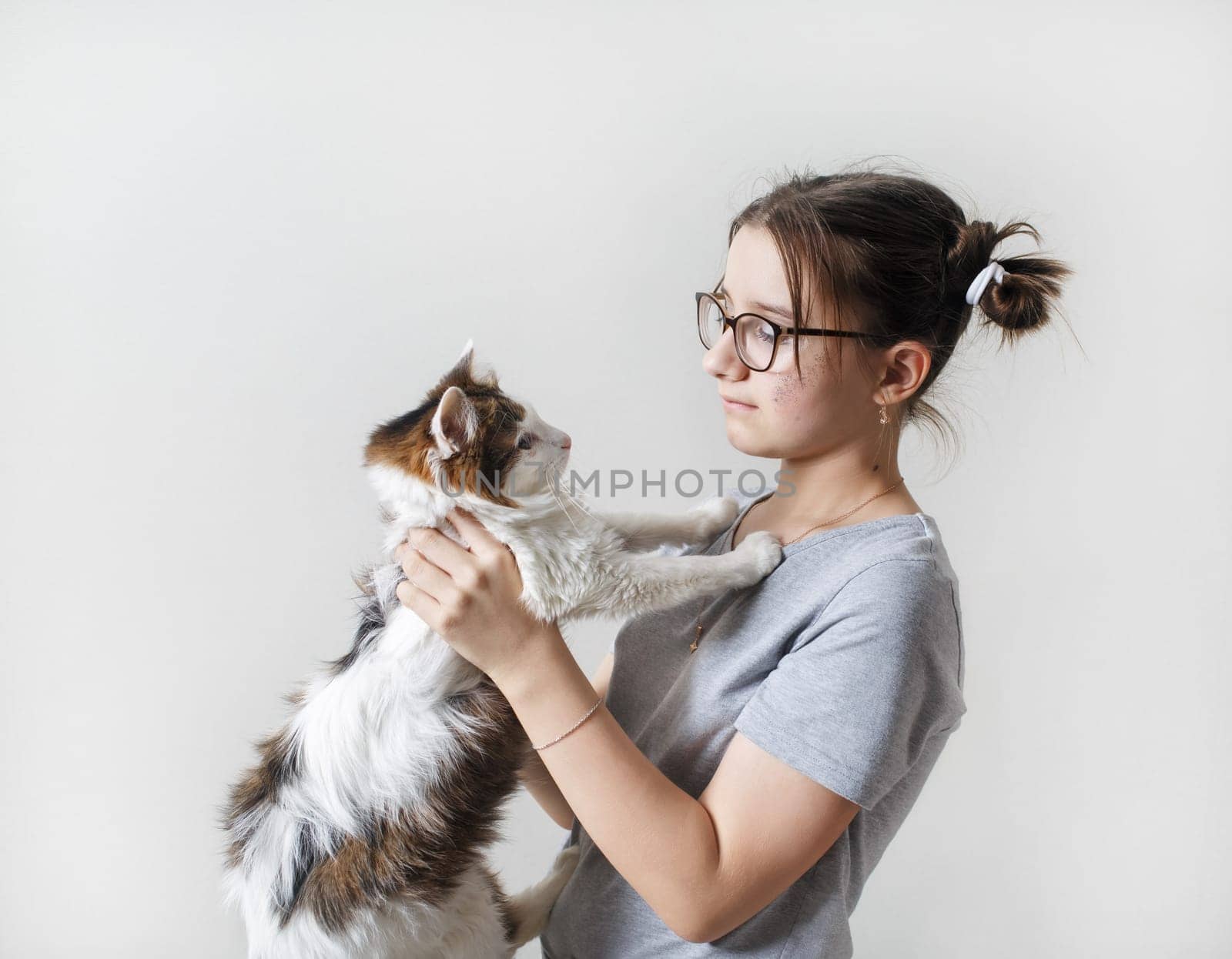Teenage girl holding cat in her arms.
