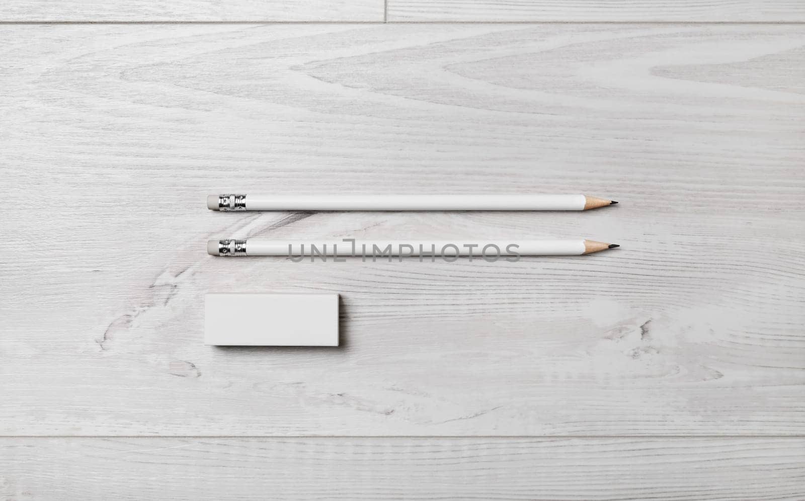 Two blank pencils and eraser on wooden background. Flat lay.