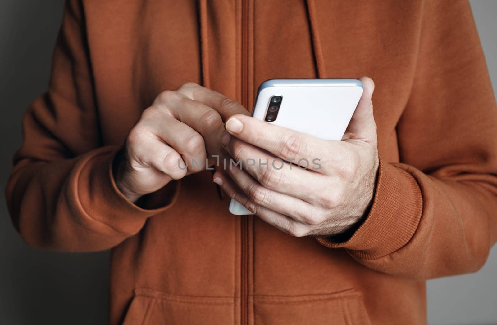 Smartphone in male hands. Man uses mobile phone.