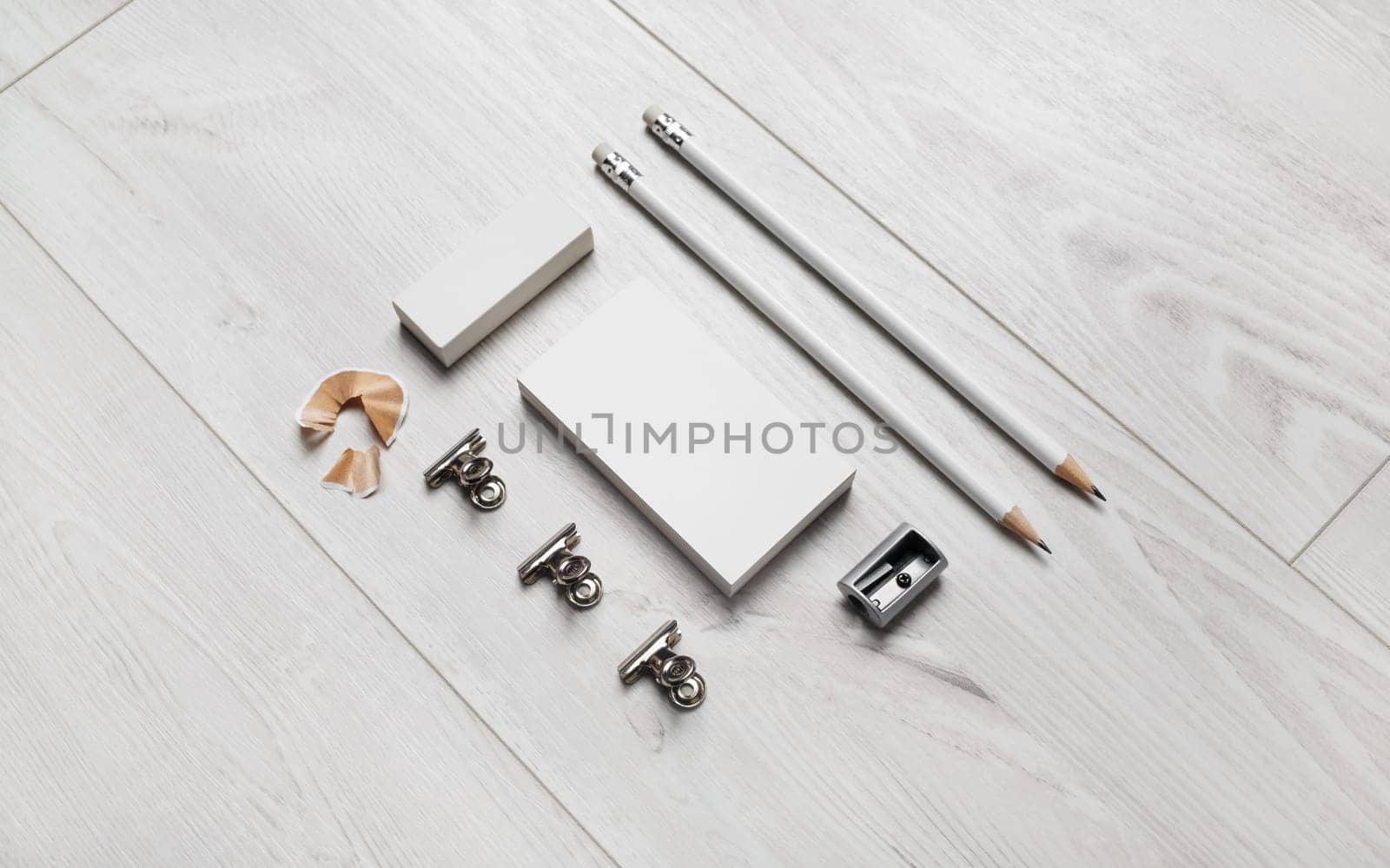 Blank business card, pencils, eraser and sharpener on wooden background. Blank branding identity set.