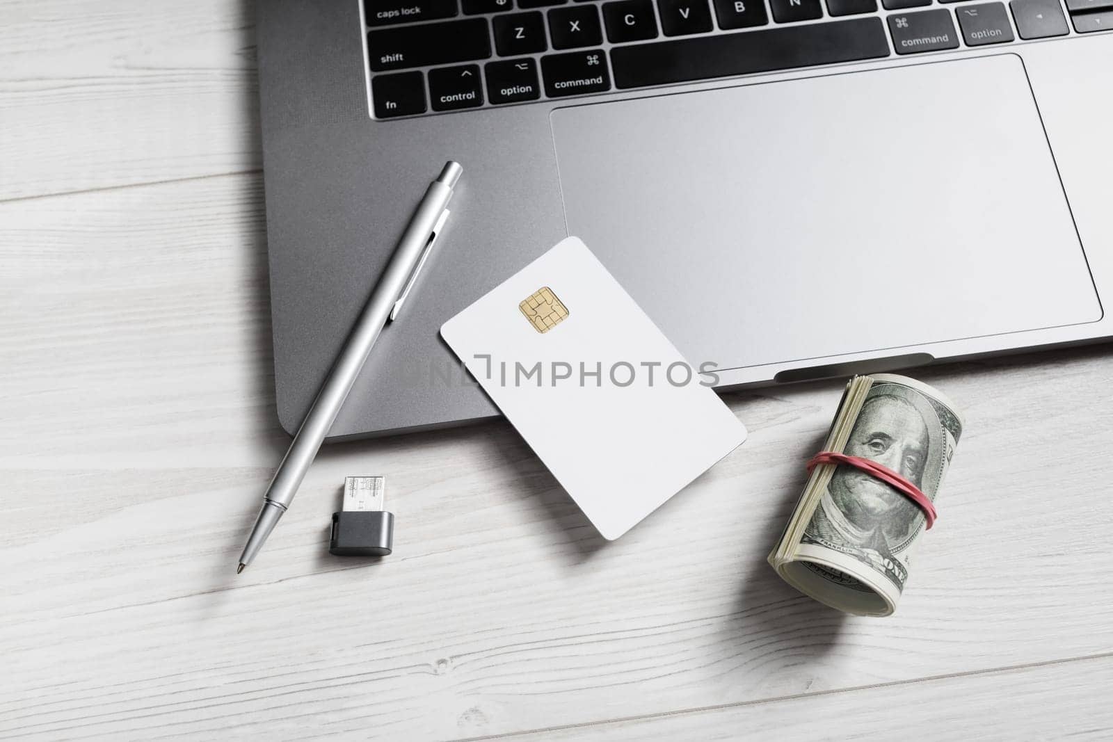 Online business concept. Money, blank credit card, pen, flash drive and laptop keyboard.