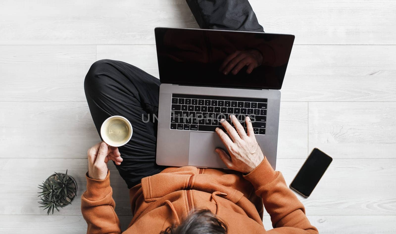 Businessman works at home during the coronavirus pandemic. Freelancer with laptop works while sitting on the floor. Online training.