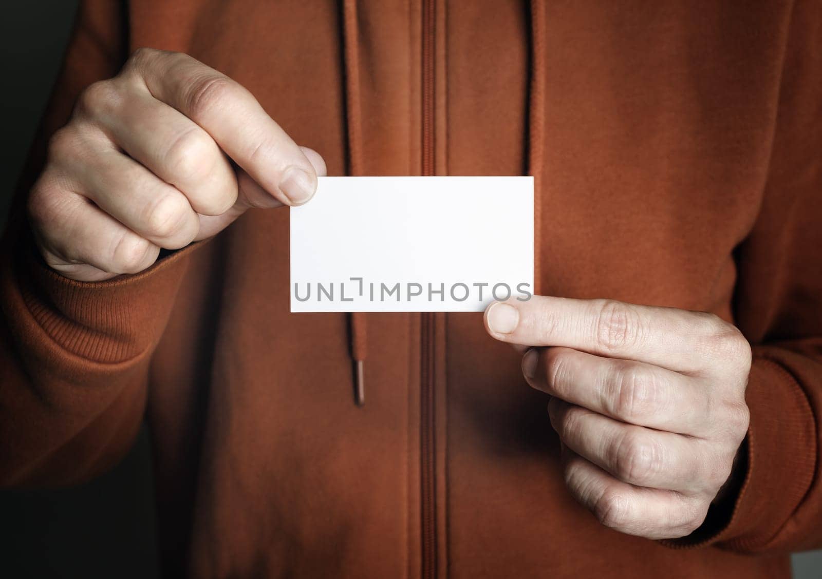 Man holding and showing blank white business card.