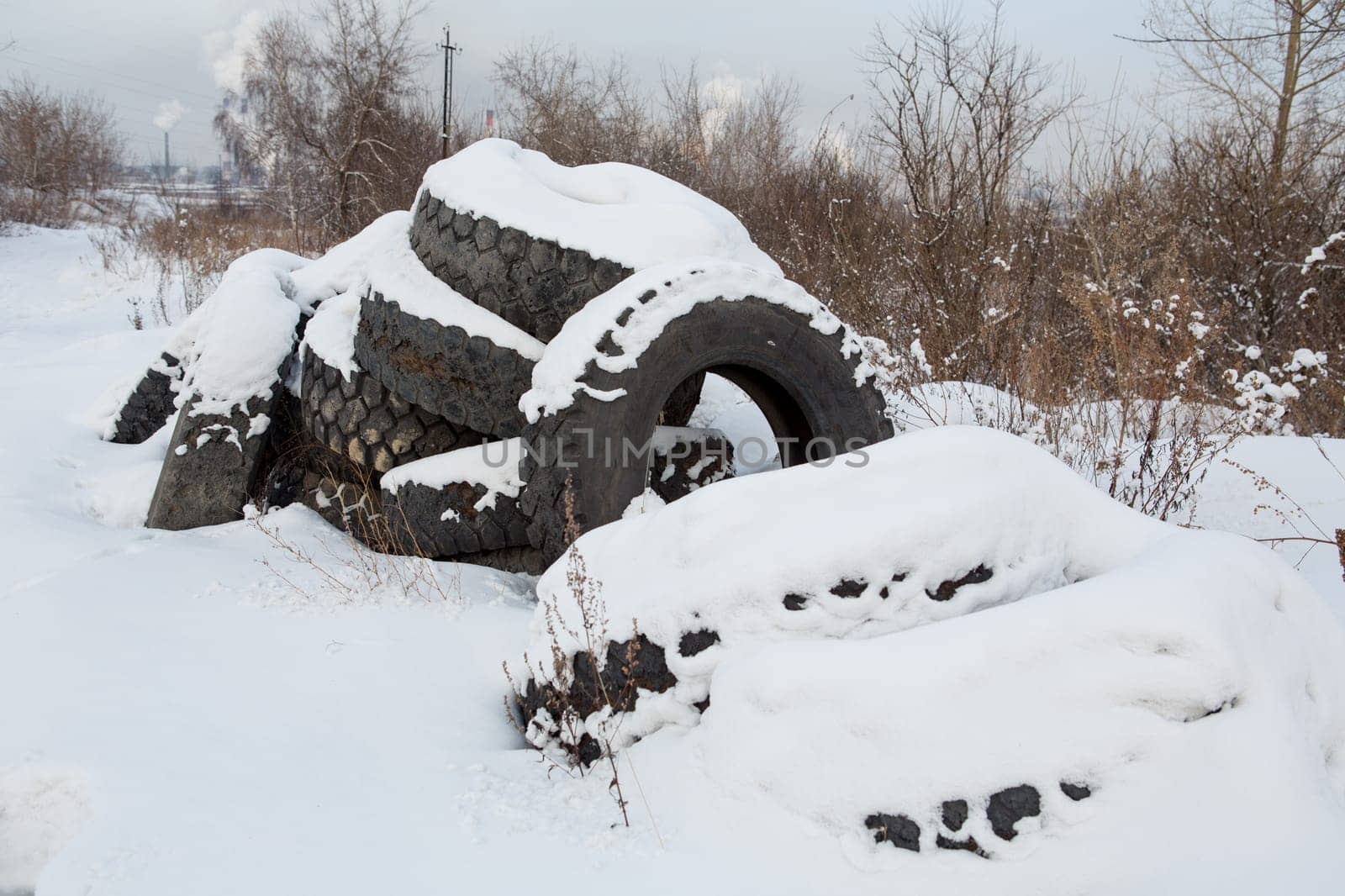old discarded tires in the snow.environmental pollution.