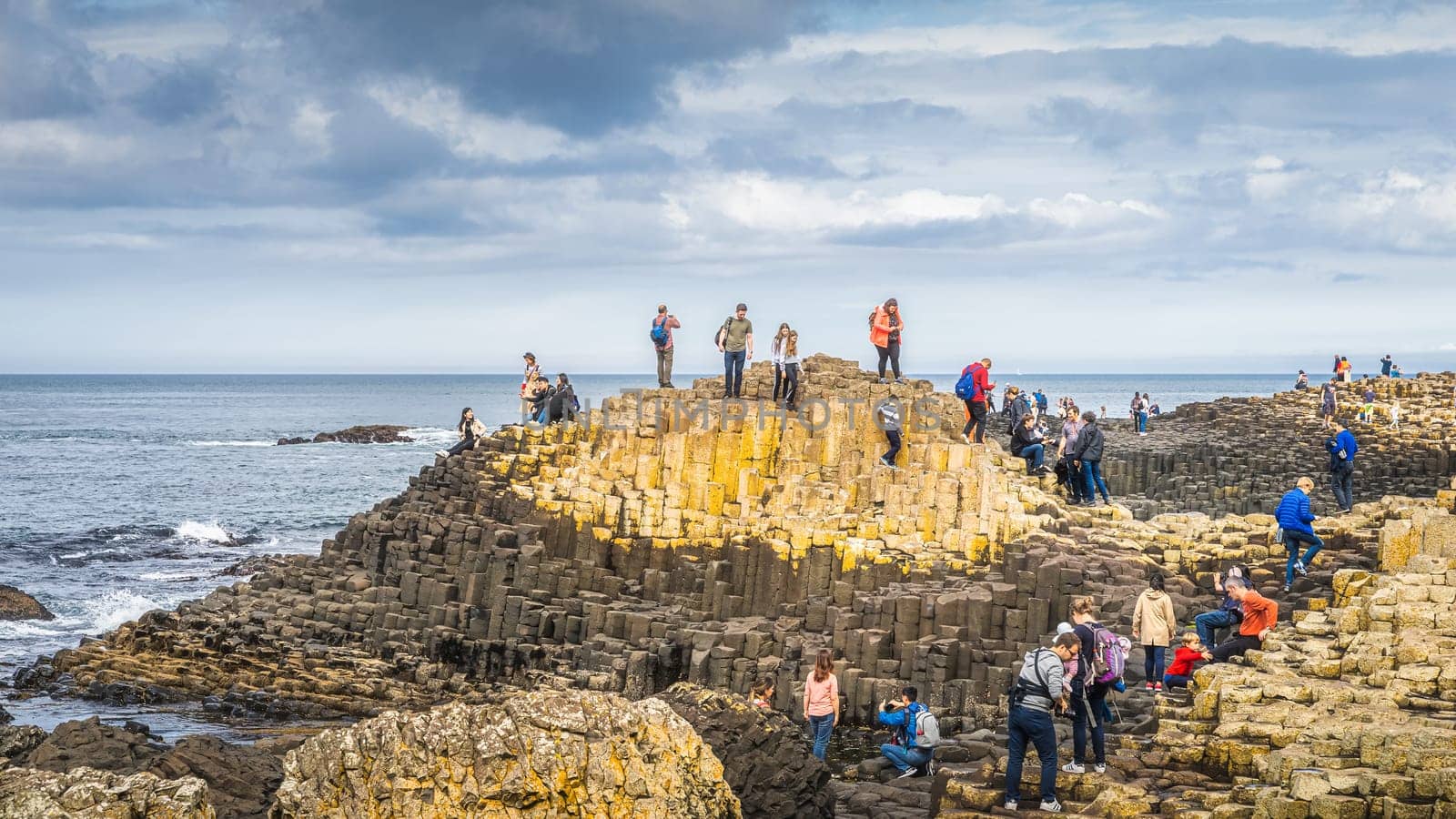 Bushmills, Northern Ireland, Aug 2019 Tourists sightseeing hexagonal rock formation in Giants Causeway, Wild Atlantic Way and UNESCO world heritage