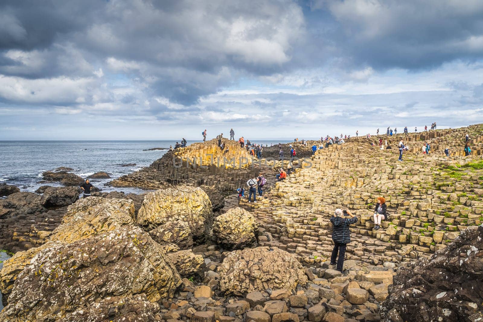 Bushmills, Northern Ireland, Aug 2019 Tourists sightseeing hexagonal rock formation in Giants Causeway, Wild Atlantic Way and UNESCO world heritage