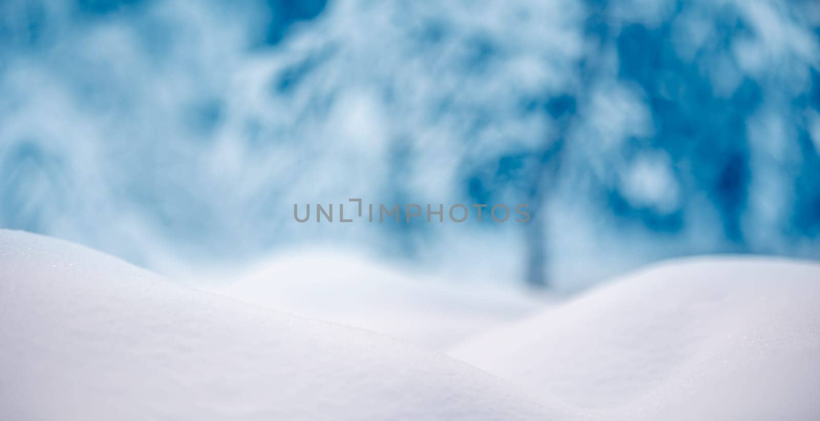 Snowy background with closeup view of the wavy snowdrifts. Concept of the wallpaper, background and backdrop.