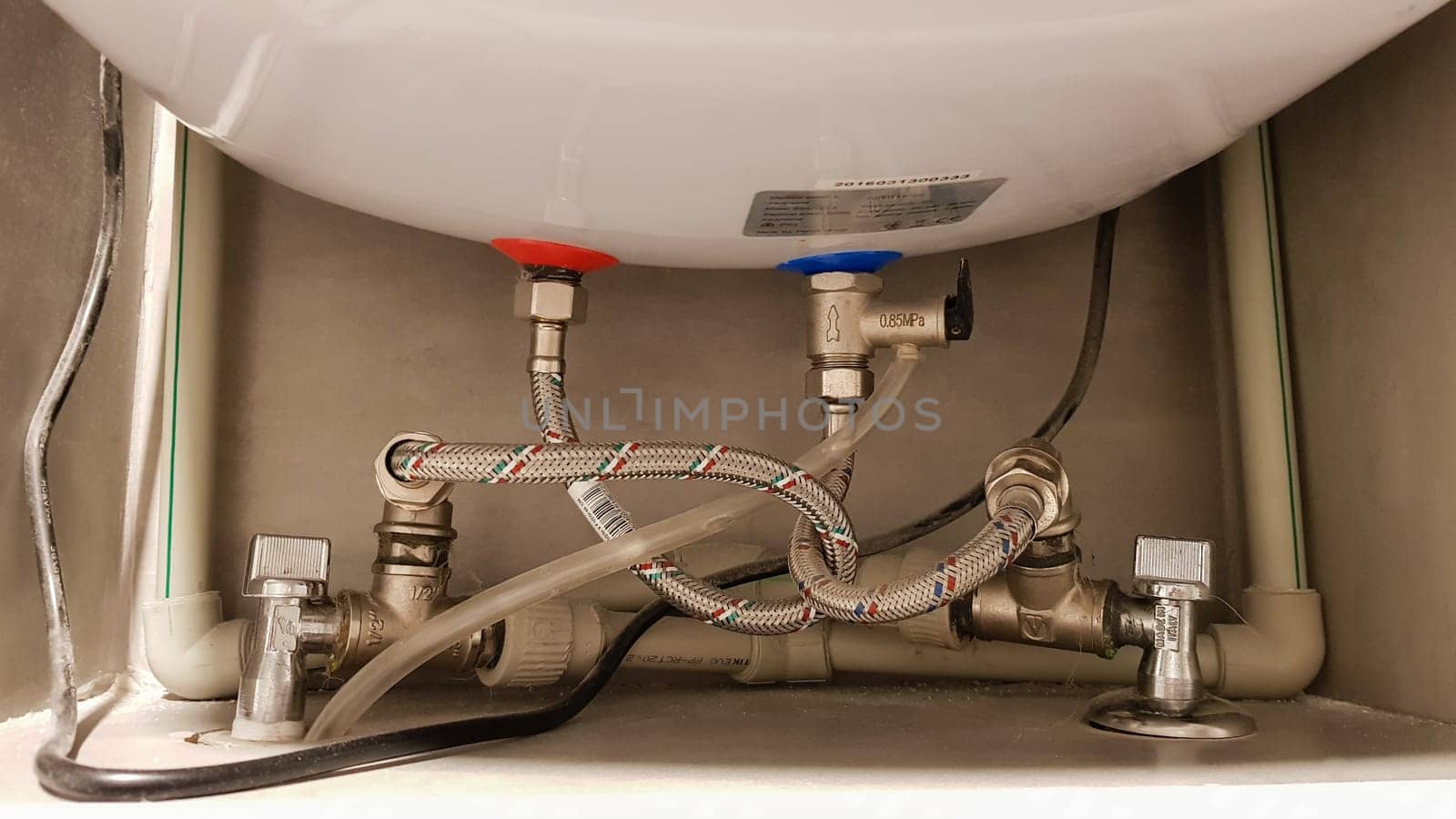 Connection of water supply, hot and cold water to the boiler. Hose for hot and cold water in the bathroom. Plumbing connections for a domestic electric water heater
