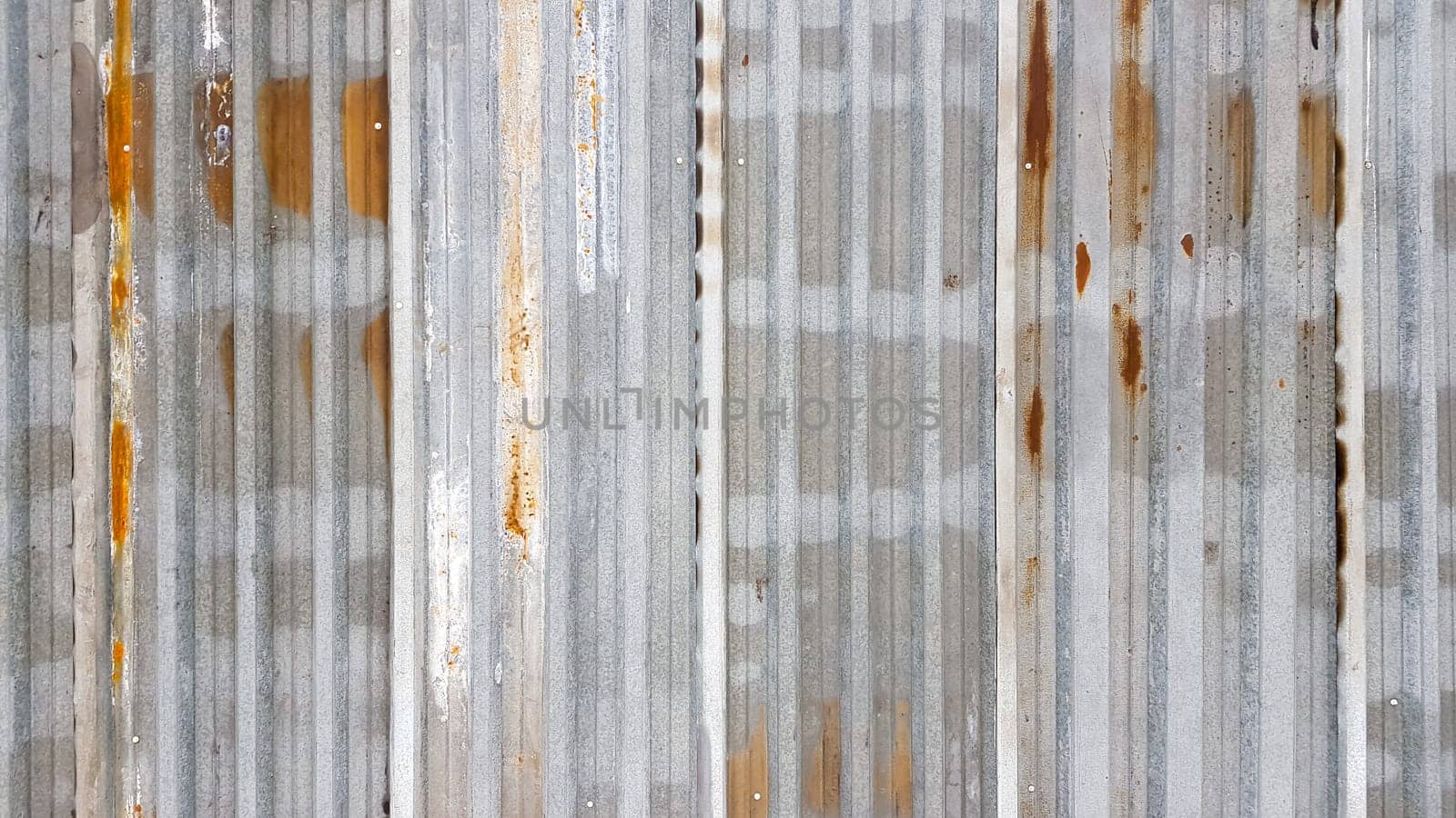 A rusty and weathered piece of corrugated metal. Corroded galvanized iron sheet. old zinc wall background