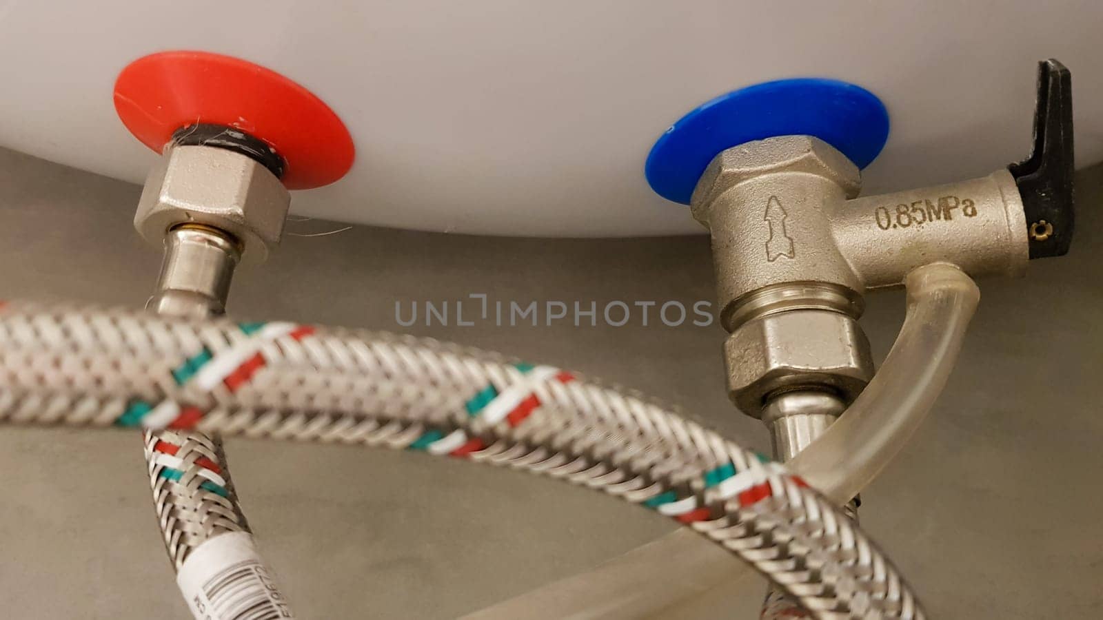 Connection of water supply, hot and cold water to the boiler. Hose for hot and cold water in the bathroom. Plumbing connections for a domestic electric water heater