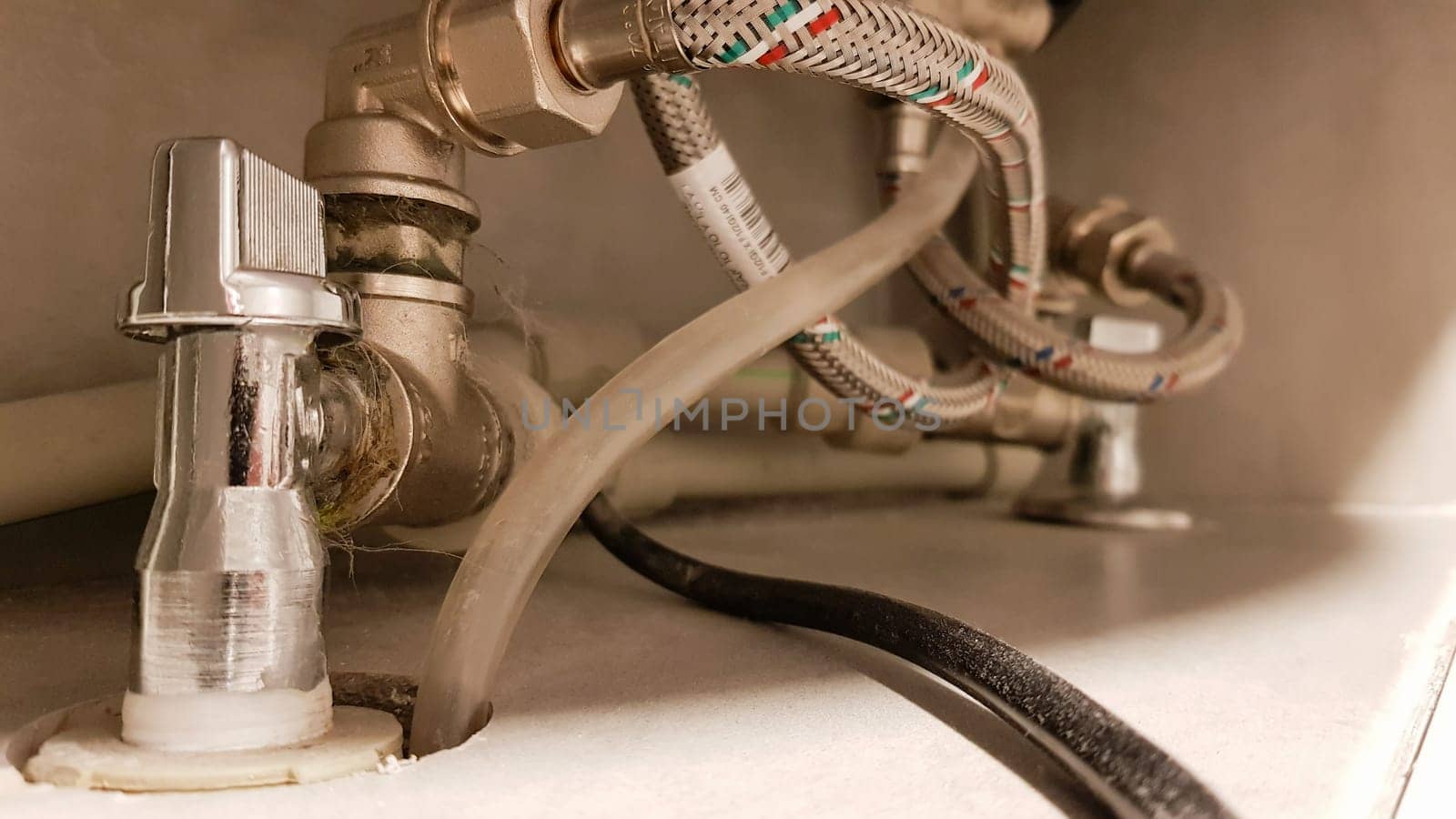 Connection of water supply, hot and cold water to the boiler. Hose for hot and cold water in the bathroom. Plumbing connections for a domestic electric water heater