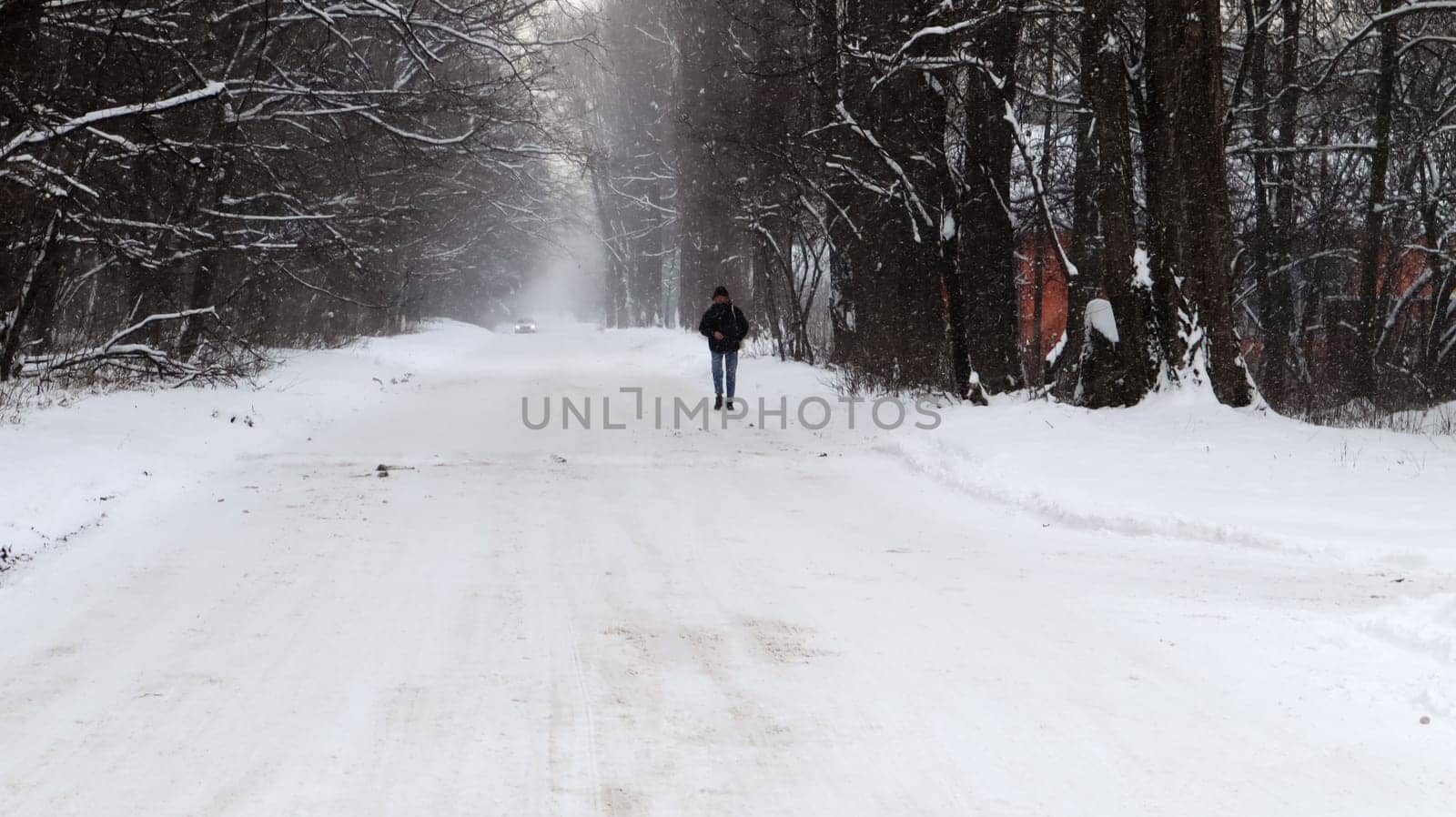 Winter landscape. Snow-covered trail in the city park. Snow covered trees in a winter forest with a road. Ukraine, Kiev - January 16, 2021