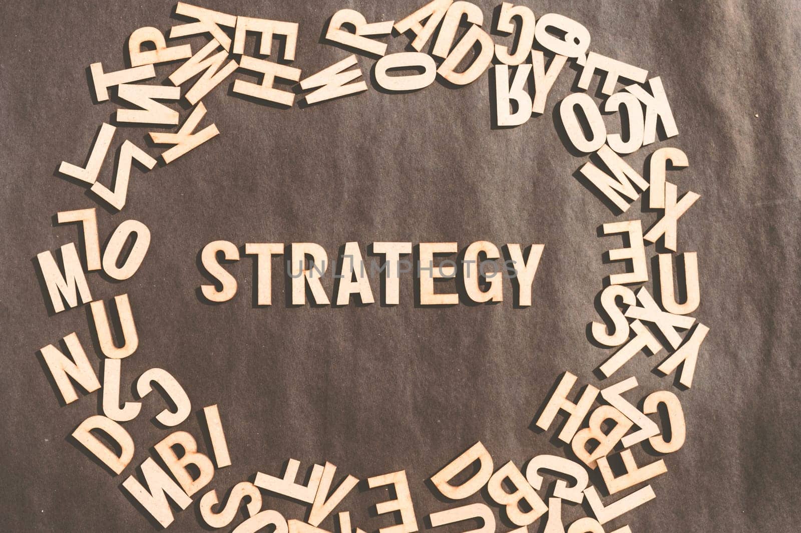 Strategy Word In Wooden Cube Alphabet Letters Top View On A rustic paper Background.