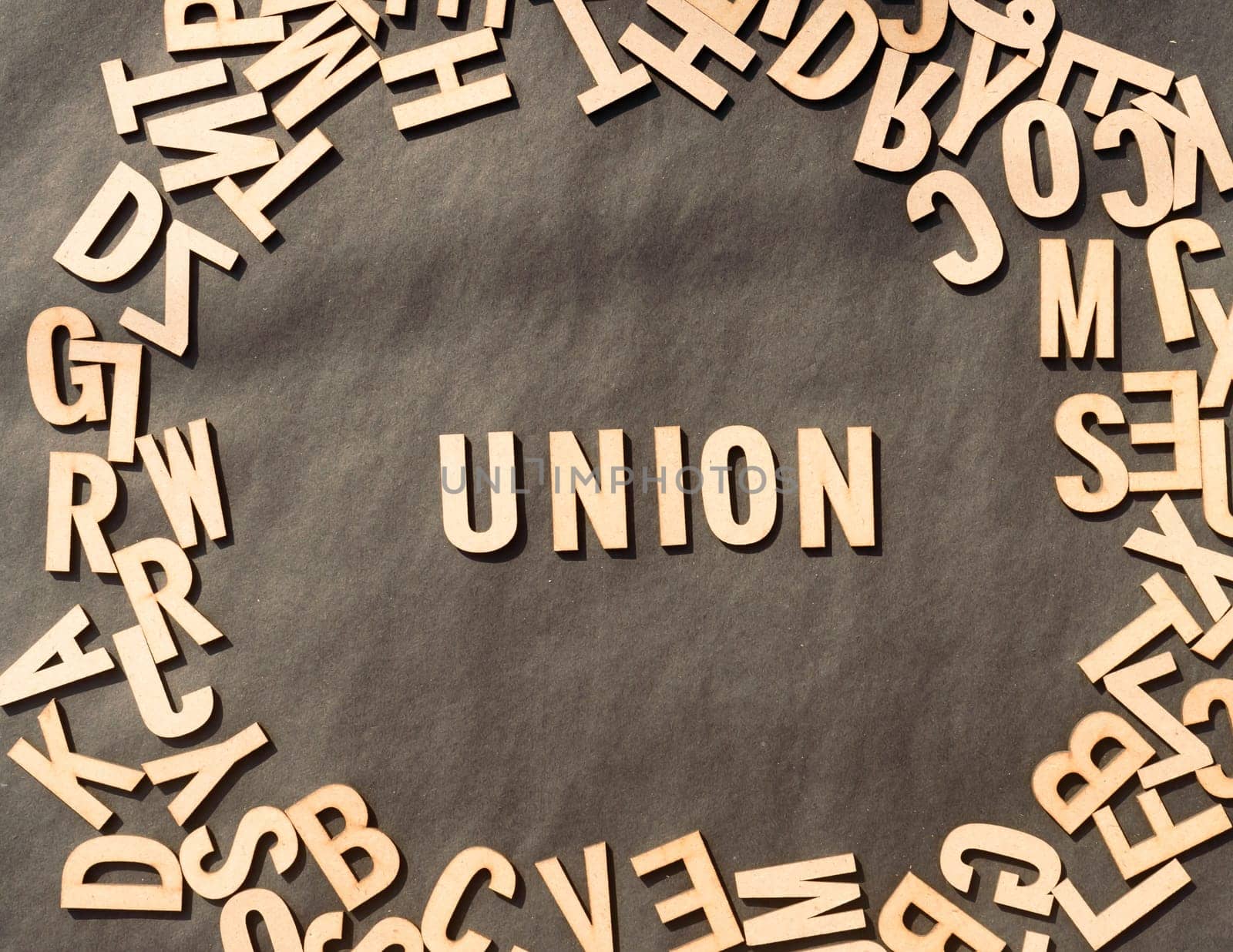 Union Word In Wooden Cube Alphabet Letters Top View On A rustic paper Background.