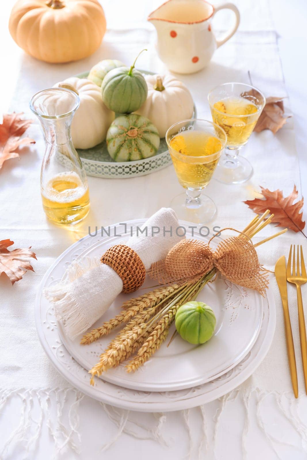 Place settings for Thanksgiving with pumpkins, ears and apple wine
