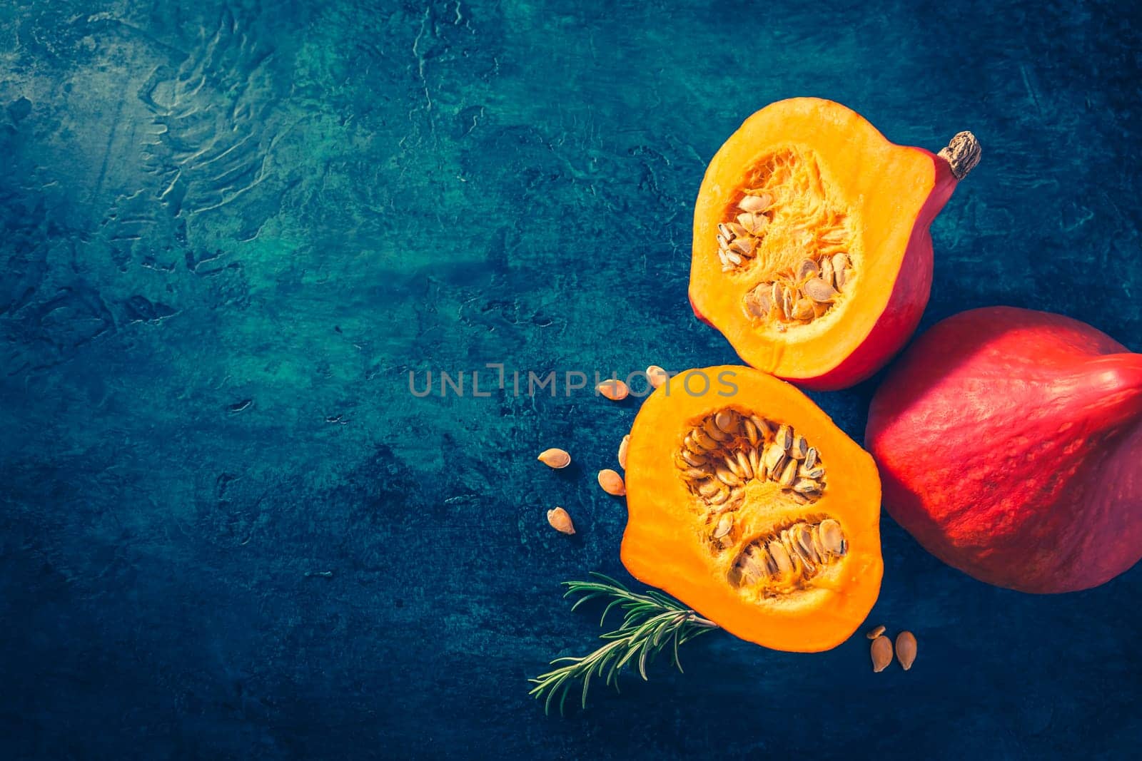 Organic pumpkin with seeds ready for cooking on blue background with copy space