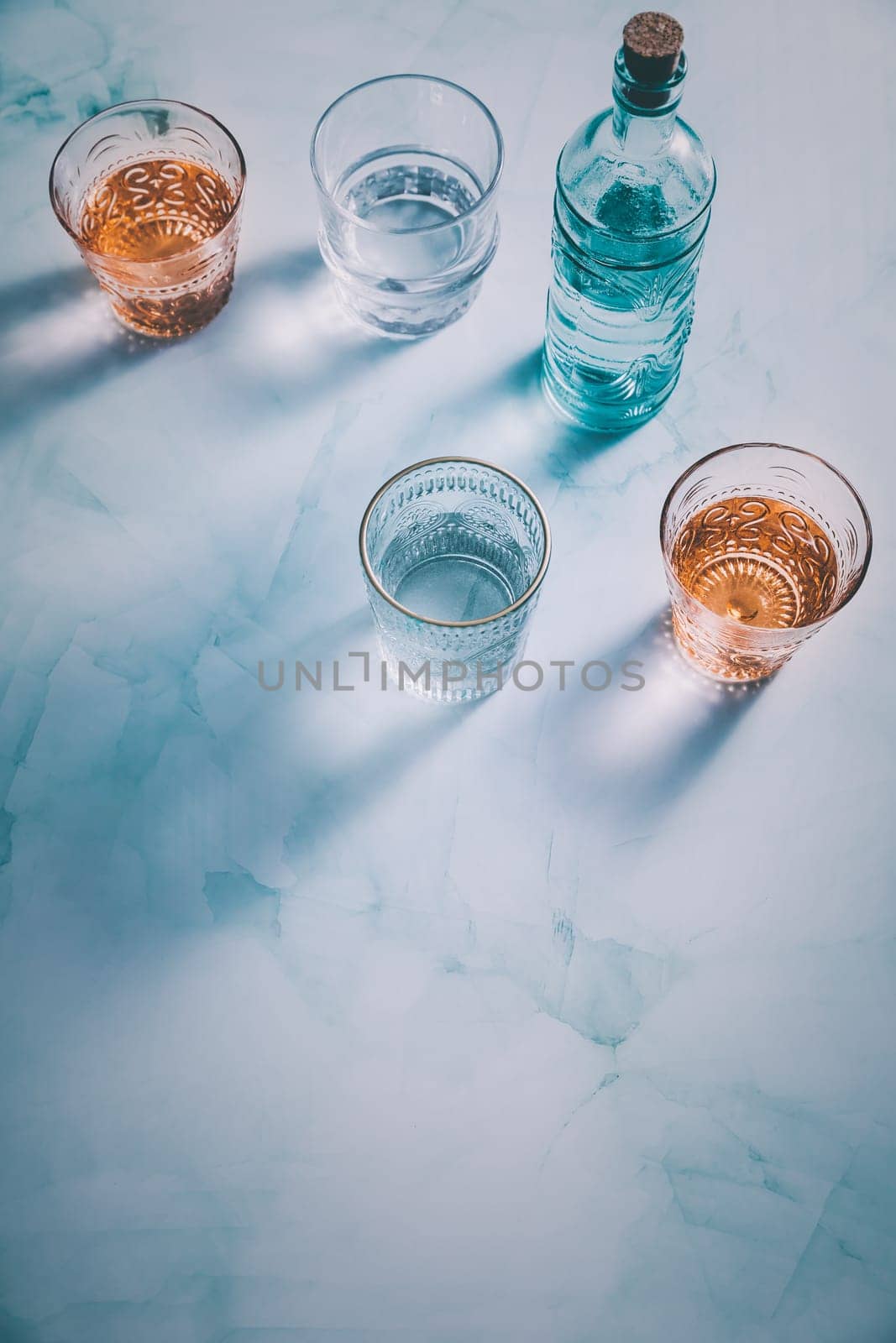 Water in vintage glasses with bottle