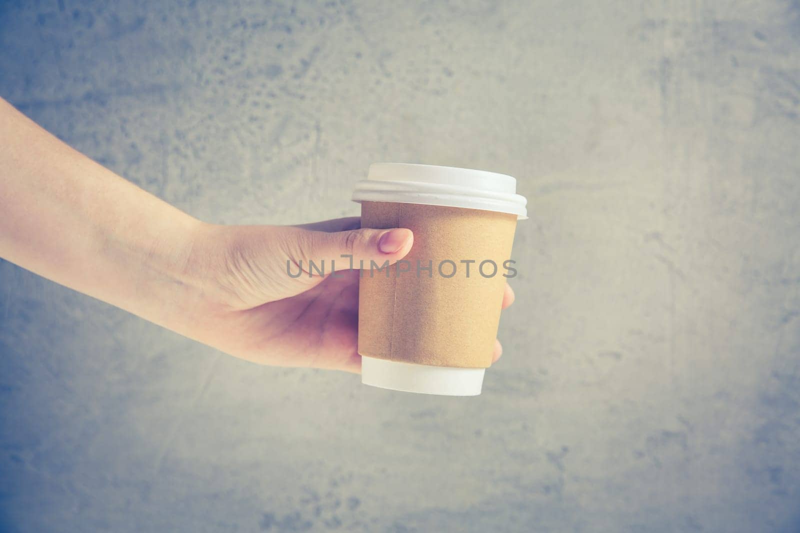 Hand holding disposable coffee cup
