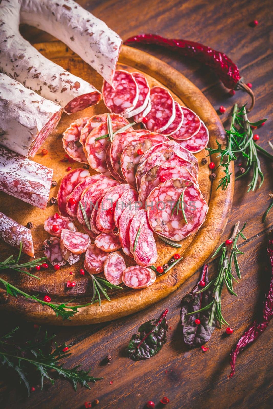 Charcuterie - Assortment of air-dried salami and sausage on wooden cutting board with spices