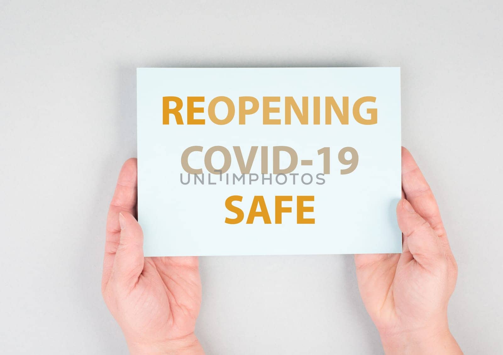 Reopening covid-19 safe, hands hold paper, message, information pandemic, grey background, sign with text