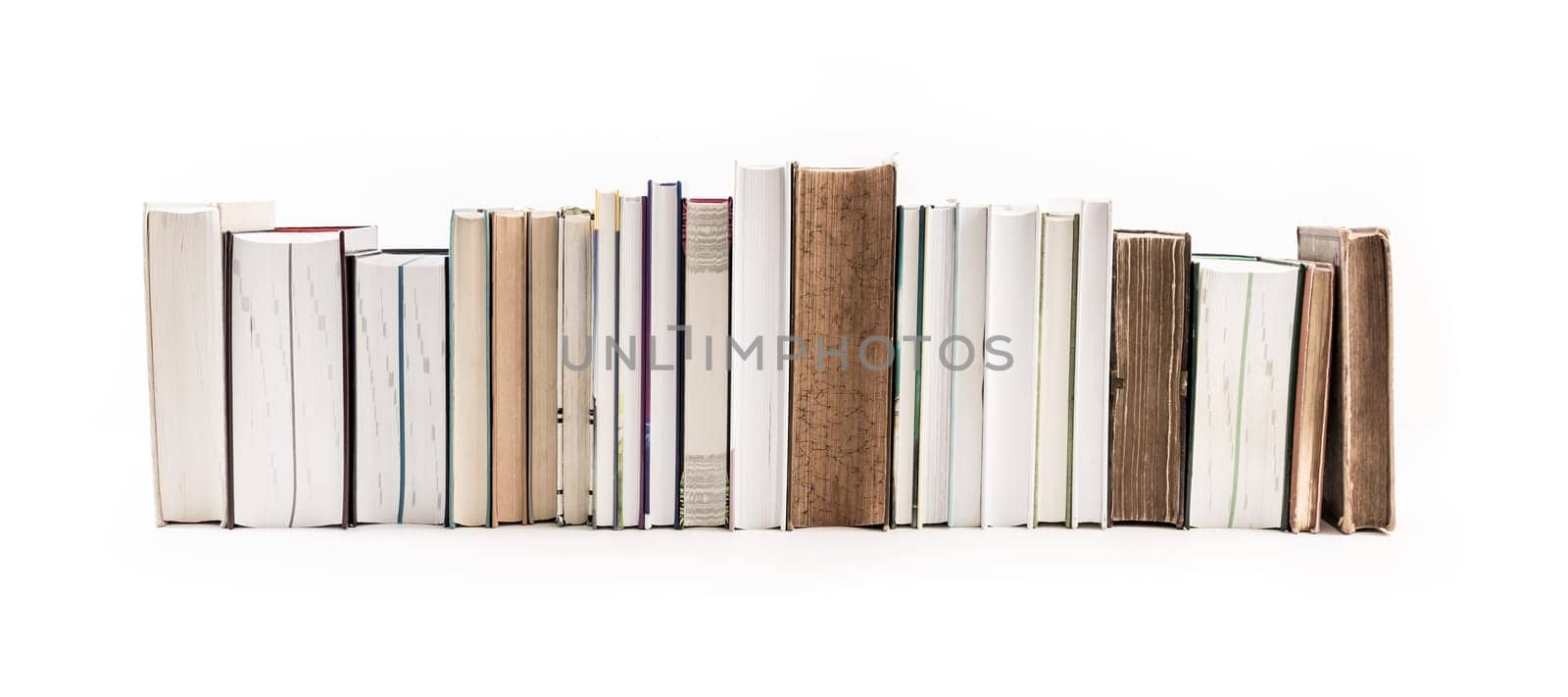 Assortment of new and old books in a row isolated on white background.