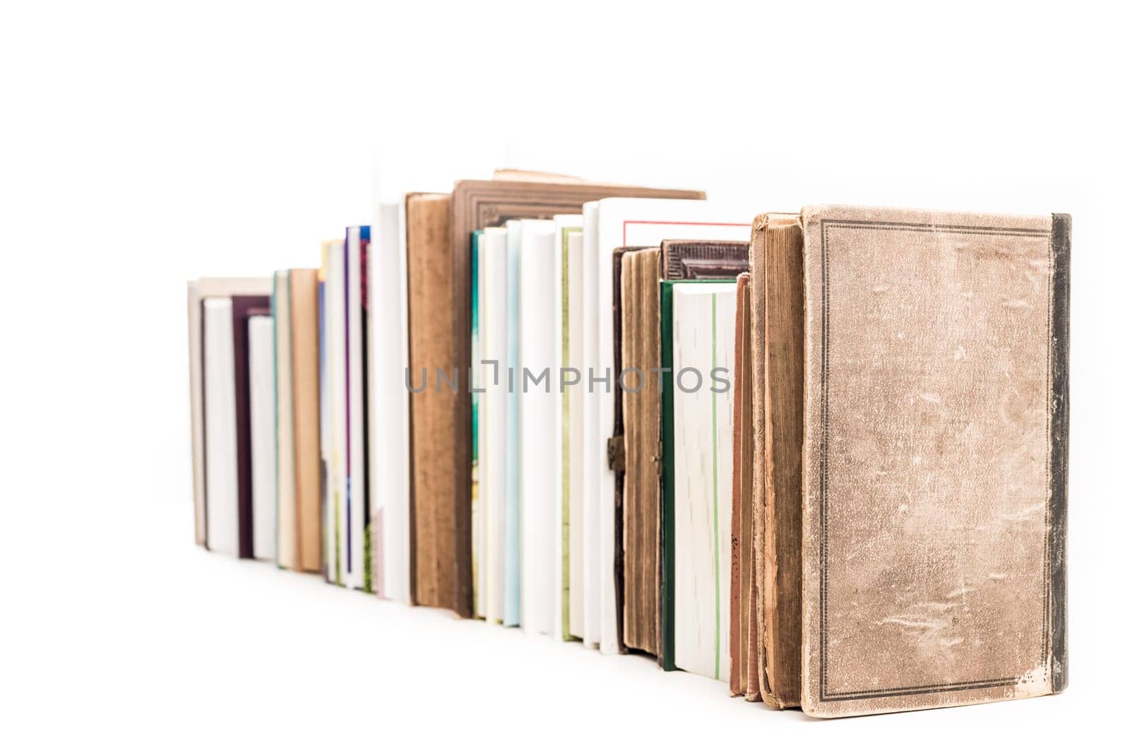 Assortment of new and old books in a row isolated on white background.