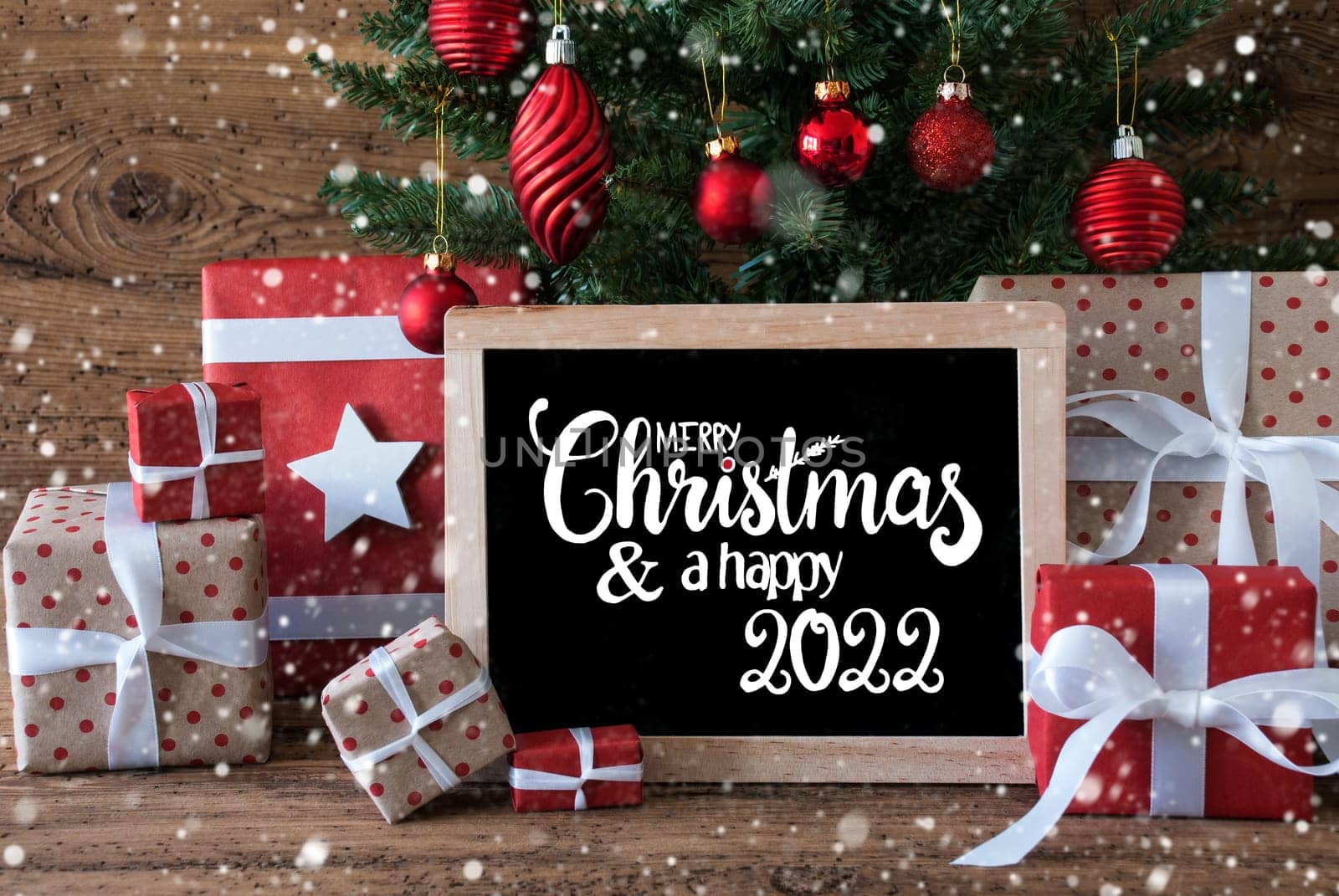 Blackboard With English Text Merry Christmas And A Happy 2022. Christmas Tree With Decoration Like Snowflakes, Gifts And Presents,Balls
